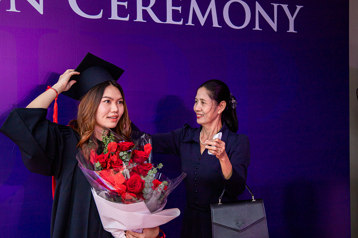 Graduate holding bouquet of flowers with family member at the UArizona AUPP Graduation Ceremony June