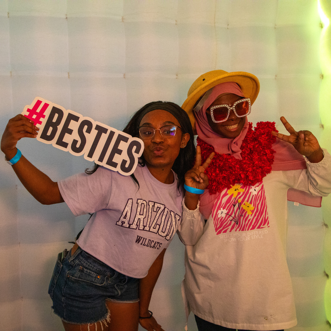Two student pose for a photo in the photobooth