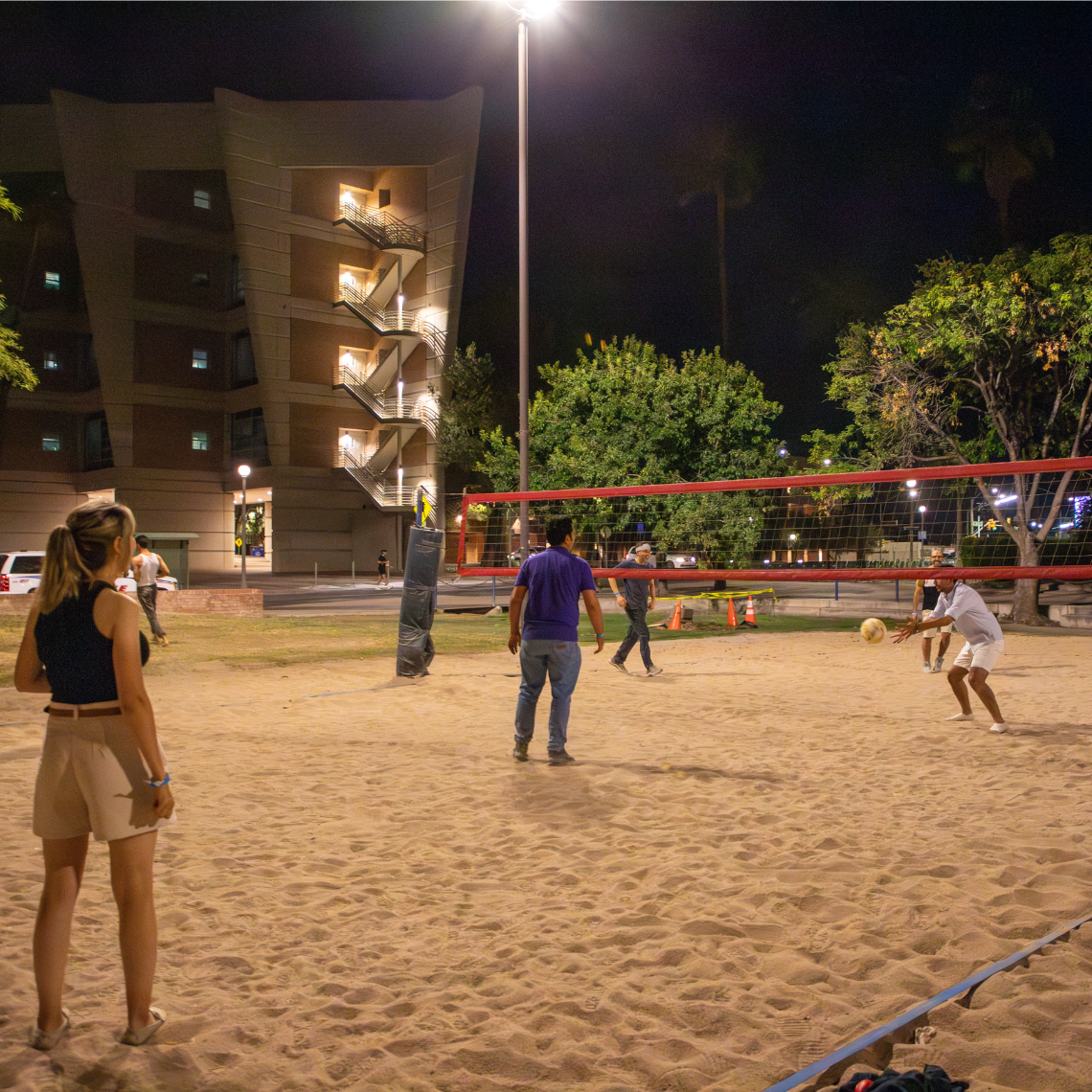 Students play volleyball on the sand courts