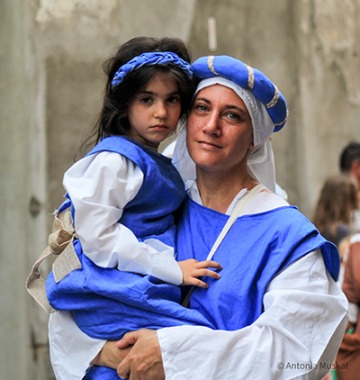 Festa Della Palombella - image of woman holding child in Italian festival clothing
