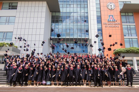 AUPP + UArizona dual degree graduates throwing their graduation caps in the air