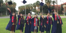 Seven International Dual Degree students at  UArizona wearing graduation gowns and throwing their gr