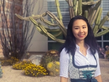 Student Mandy Han in front of UArizona Student Union, with cactus in background