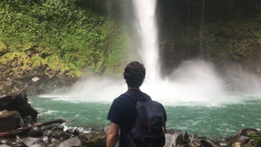 UA Study Abroad Student Brenden Barness during study abroad in Costa Rica, wearing a backpack and facing away toward a waterfall.